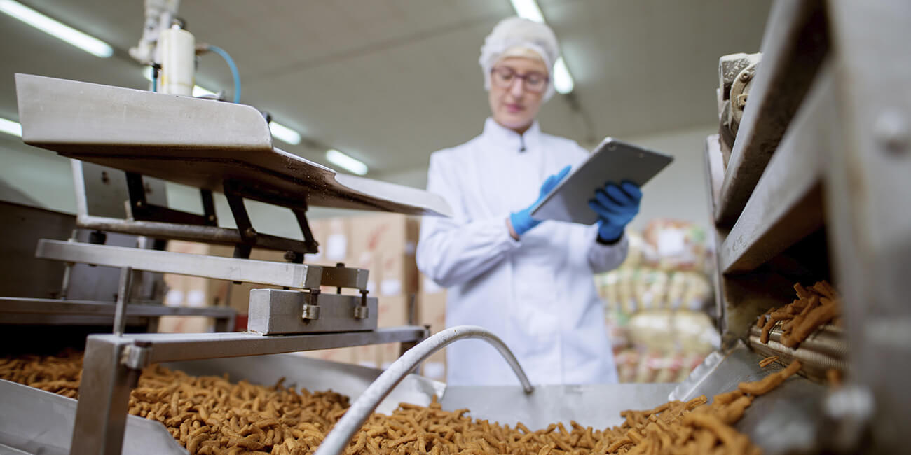 Woman performing quality check on snack in food facility